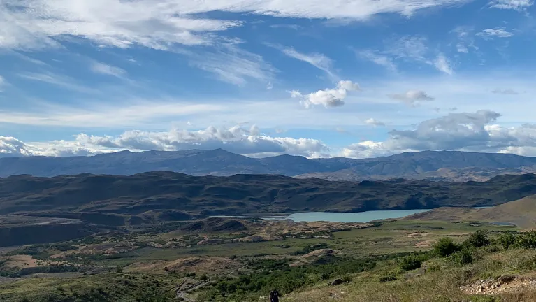 A landscape of a mountain range with a body of water near the foreground 