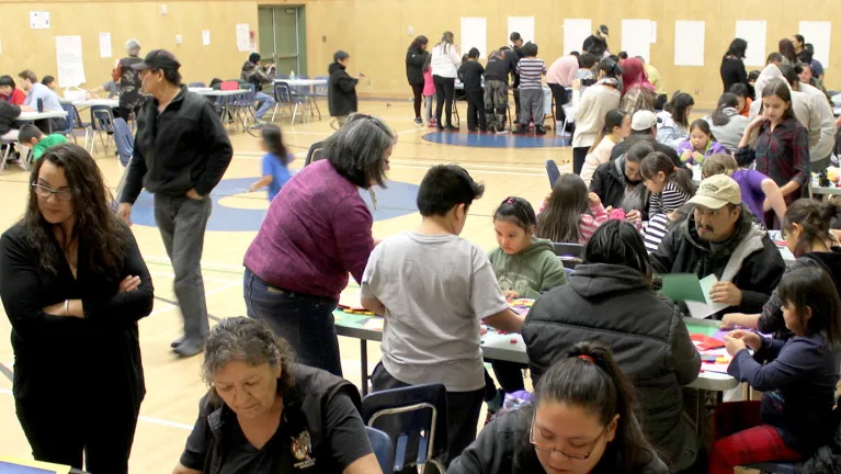 People participating in math games at various tables.